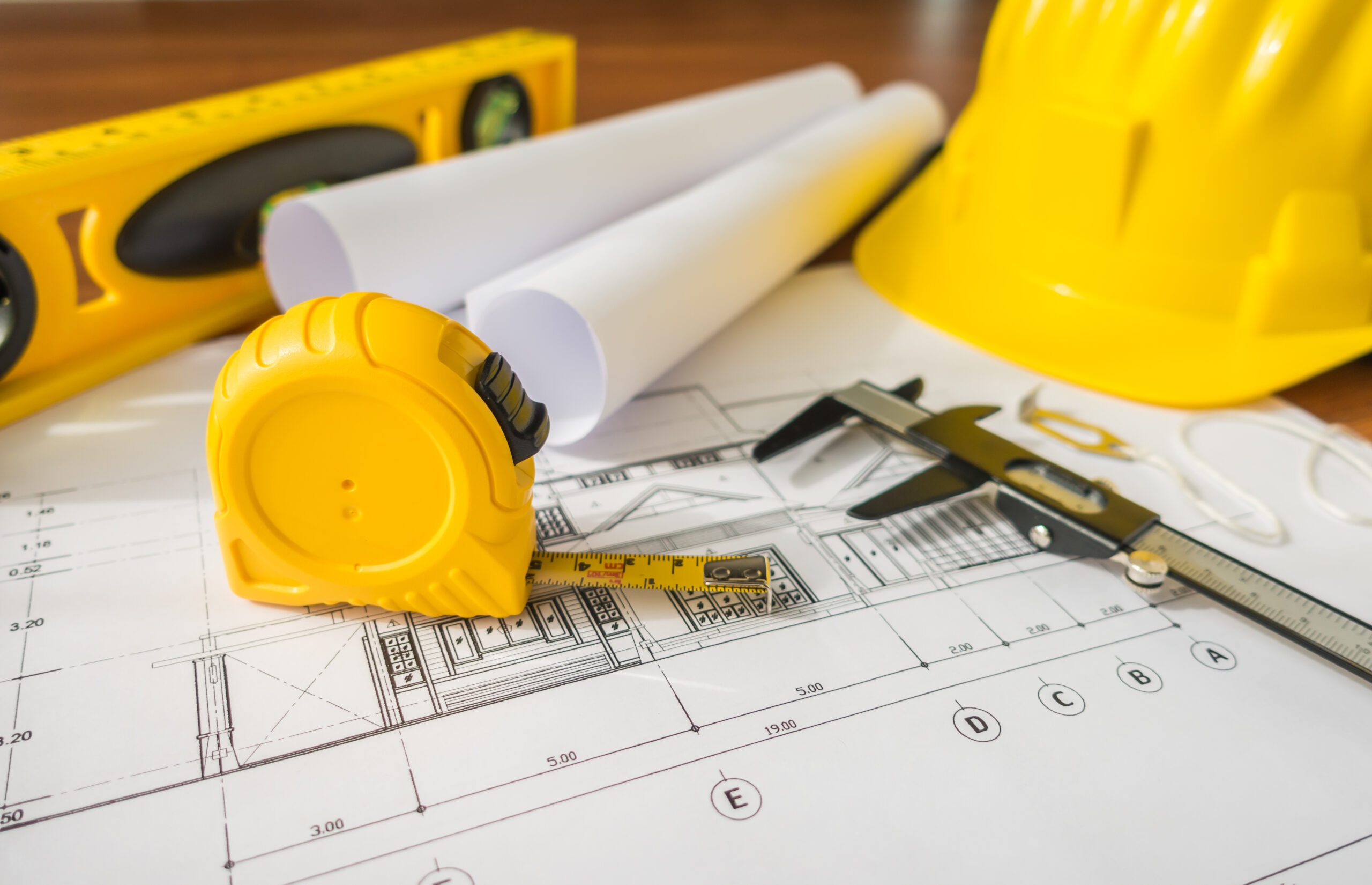construction plans with yellow helmet drawing tools bluep 1 scaled